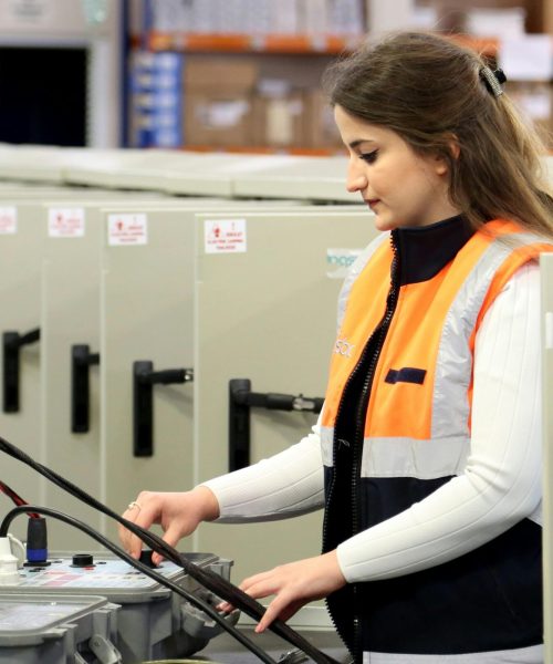 Técnica electricista realizando mantenimiento de instalaciones eléctricas en Madrid